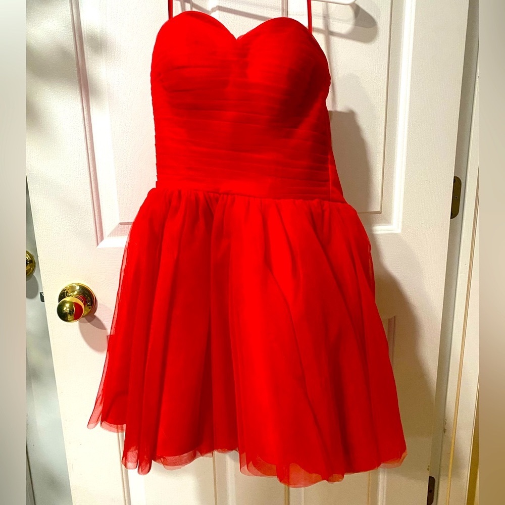 Strapless bright red formal dress with a lace up back and a big red bow